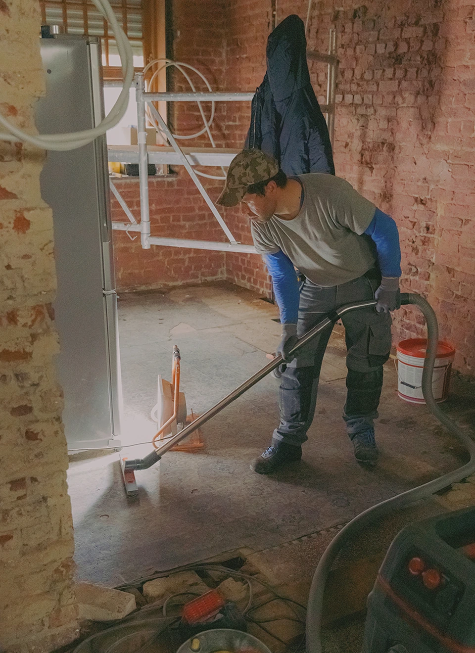 Person vacuuming in a renovation space.