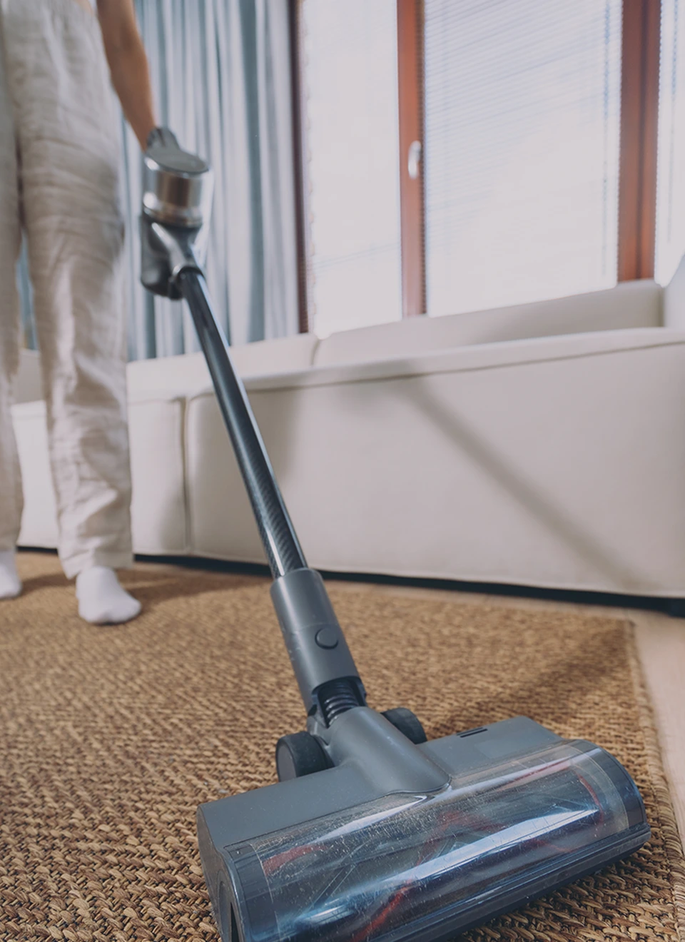 Person using a vacuum on a rug.