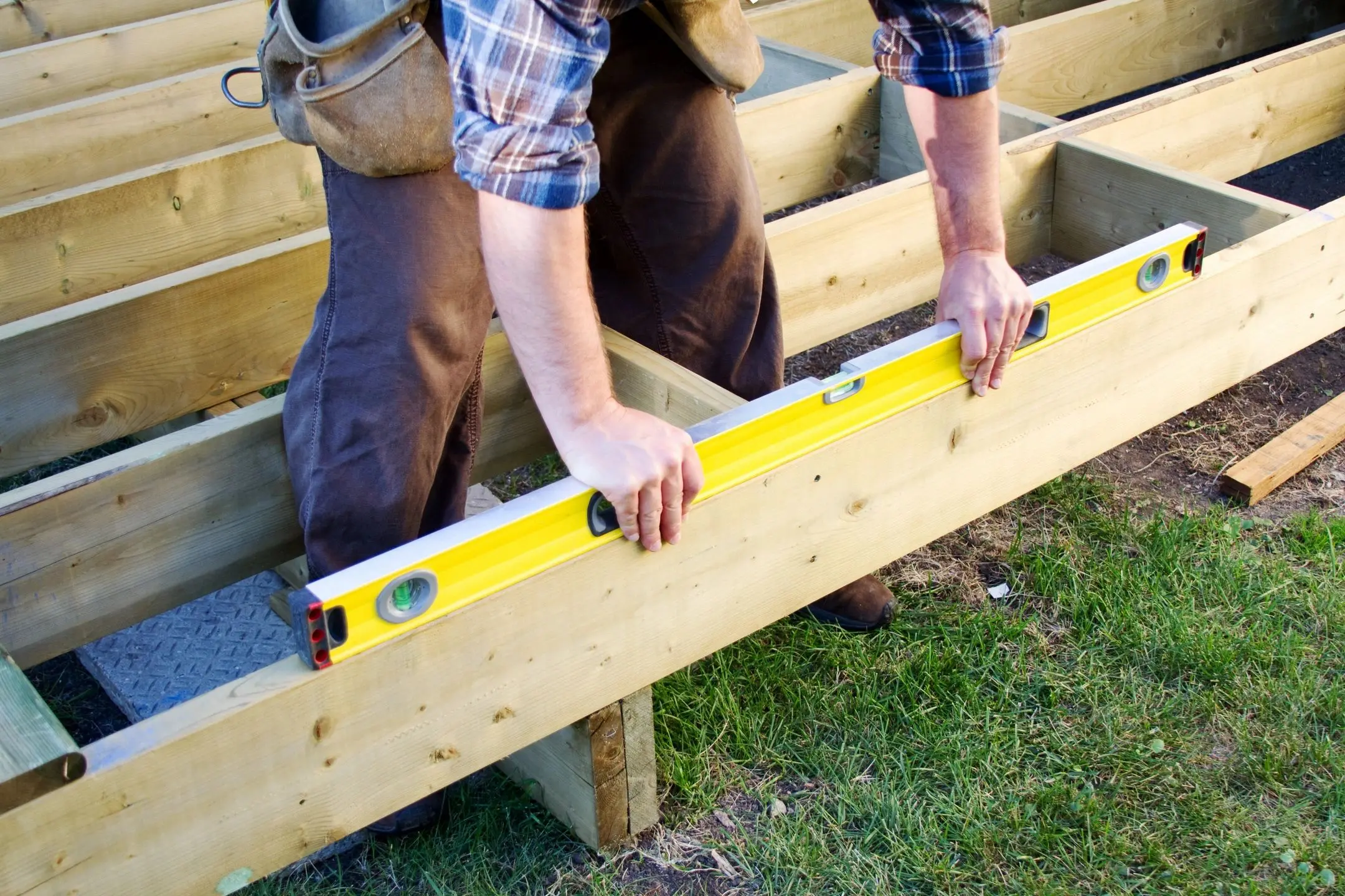 Two men are working on a wooden structure.