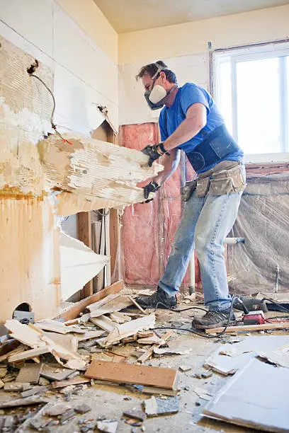 A man in blue shirt using a power tool.